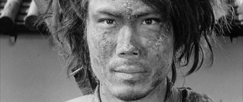 Movie still from “Black Cat” (1968), directed by Kaneto Shindô – A person with dirt all over his face; Extreme Close Up shot, Overhead angle