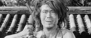Movie still from “Black Cat” (1968), directed by Kaneto Shindô – A man with long hair holding a knife; Close Up shot, Over the shoulder angle