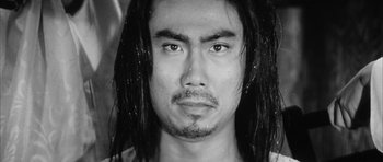 Movie still from “Black Cat” (1968), directed by Kaneto Shindô – Black and white photograph of a man with long black hair; Close Up shot, Low angle