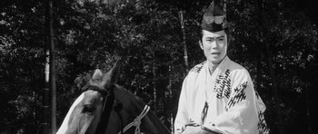 Movie still from “Black Cat” (1968), directed by Kaneto Shindô – A man wearing a hat standing next to a horse; Close Up shot, Low angle