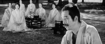 Movie still from “Black Cat” (1968), directed by Kaneto Shindô – A man sitting in front of a group of women; Close Up shot, Over the shoulder angle