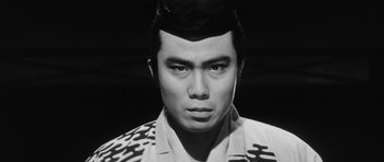 Movie still from “Black Cat” (1968), directed by Kaneto Shindô – A black and white photo of a man with a hat; Close Up shot, Low angle