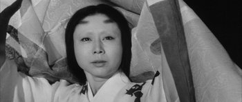 Movie still from “Black Cat” (1968), directed by Kaneto Shindô – A black - and - white photo of a woman in a kimono; Close Up shot, Overhead angle