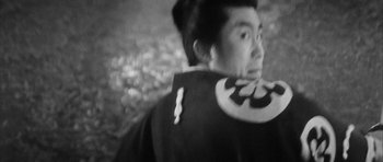 Movie still from “Black Cat” (1968), directed by Kaneto Shindô – A man in a black and white photo with a bat on his shoulder; Close Up shot, Low angle