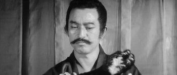 Movie still from “Black Cat” (1968), directed by Kaneto Shindô – A black and white photo of a man holding a cat; Close Up shot, Low angle