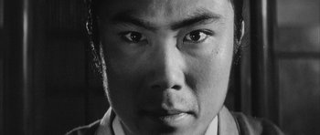 Movie still from “Black Cat” (1968), directed by Kaneto Shindô – A man's face in black - and - white; Extreme Close Up shot, Low angle