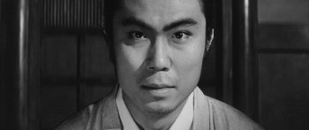 Movie still from “Black Cat” (1968), directed by Kaneto Shindô – A black - and - white photo of a man's face; Close Up shot, Low angle