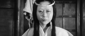 Movie still from “Black Cat” (1968), directed by Kaneto Shindô – A woman with a white face and long black hair; Close Up shot, High angle