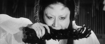 Movie still from “Black Cat” (1968), directed by Kaneto Shindô – A black and white photo of a woman holding a cat; Close Up shot, Overhead angle
