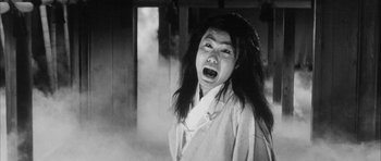 Movie still from “Black Cat” (1968), directed by Kaneto Shindô – An asian man with long hair and a white shirt is crying; Close Up shot, Low angle
