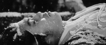 Movie still from “Black Cat” (1968), directed by Kaneto Shindô – A woman laying in the middle of a snow covered field; Extreme Close Up shot, High angle