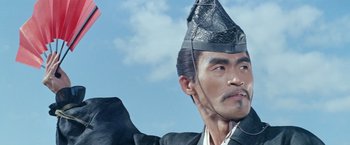 Movie still from “Kwaidan” (1964), directed by Masaki Kobayashi – A person wearing a suit and a hat; Close Up shot, Low angle