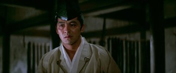 Movie still from “Kwaidan” (1964), directed by Masaki Kobayashi – A man in a white robe wearing a green hat; Close Up shot, Low angle