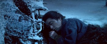 Movie still from “Kwaidan” (1964), directed by Masaki Kobayashi – A man sleeping on the ground in the snow; Medium shot, High angle