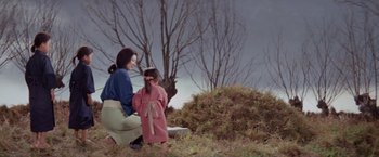 Movie still from “Kwaidan” (1964), directed by Masaki Kobayashi – A woman and a child are sitting in a field; Wide shot, High angle