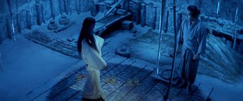 Movie still from “Kwaidan” (1964), directed by Masaki Kobayashi – A woman standing on a wooden deck next to a pile of donuts; Wide shot, High angle