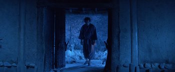Movie still from “Kwaidan” (1964), directed by Masaki Kobayashi – A man in a robe walking through a doorway; Wide shot, Low angle