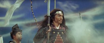 Movie still from “Kwaidan” (1964), directed by Masaki Kobayashi – A person holding a sword in their hand; Medium shot, Low angle