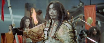 Movie still from “Kwaidan” (1964), directed by Masaki Kobayashi – A man with long black hair wearing a costume; Medium shot, Low angle