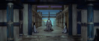 Movie still from “Kwaidan” (1964), directed by Masaki Kobayashi – A group of people sitting on a stage in front of a painting; Wide shot, High angle