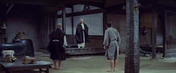 Movie still from “Kwaidan” (1964), directed by Masaki Kobayashi – A group of people standing in front of a building; Wide shot, Over the shoulder angle