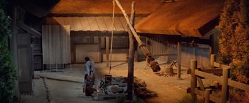 Movie still from “Kwaidan” (1964), directed by Masaki Kobayashi – A man standing next to a tree in a building; Wide shot, Low angle