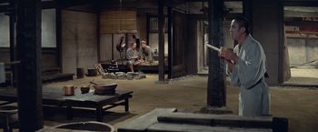 Movie still from “Kwaidan” (1964), directed by Masaki Kobayashi – Two men sitting on a bench in an old - fashioned setting; Wide shot, High angle