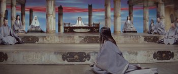 Movie still from “Kwaidan” (1964), directed by Masaki Kobayashi – A woman sitting on the ground in front of a painting of jesus; Extreme Wide shot, High angle
