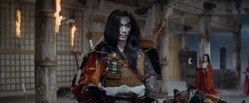 Movie still from “Kwaidan” (1964), directed by Masaki Kobayashi – A man with long black hair and a white face; Medium shot, Over the shoulder angle