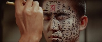 Movie still from “Kwaidan” (1964), directed by Masaki Kobayashi – A person with writing on their face and writing on their face; Extreme Close Up shot, Overhead angle