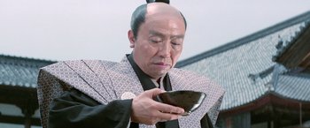 Movie still from “Kwaidan” (1964), directed by Masaki Kobayashi – An older man looking at his cell phone; Close Up shot, Low angle