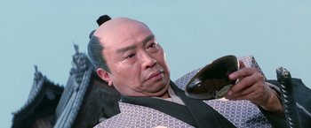 Movie still from “Kwaidan” (1964), directed by Masaki Kobayashi – A man with a bald head and a black wig; Close Up shot, Low angle
