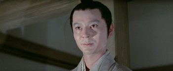 Movie still from “Kwaidan” (1964), directed by Masaki Kobayashi – A man in a white shirt is looking at the camera; Close Up shot, Low angle