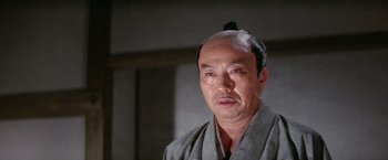 Movie still from “Kwaidan” (1964), directed by Masaki Kobayashi – An asian man with a shaved head and a beard; Close Up shot, Low angle