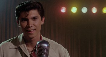 A man with a microphone in front of lights