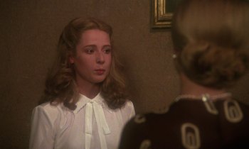 Movie still from “La Cage aux Folles” (1978), directed by Édouard Molinaro – A young woman wearing a white shirt and a white bow tie; Close Up shot, Over the shoulder angle