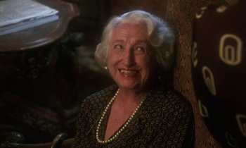 Movie still from “La Cage aux Folles” (1978), directed by Édouard Molinaro – An older woman wearing a black and white dress and pearls; Close Up shot, Low angle