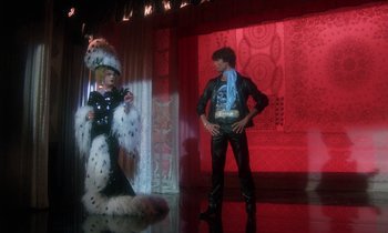 Movie still from “La Cage aux Folles” (1978), directed by Édouard Molinaro – A man and a woman dressed up in costume; Wide shot, Low angle