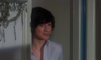 Movie still from “La Cage aux Folles” (1978), directed by Édouard Molinaro – A young man standing in front of a mirror; Close Up shot, Over the shoulder angle