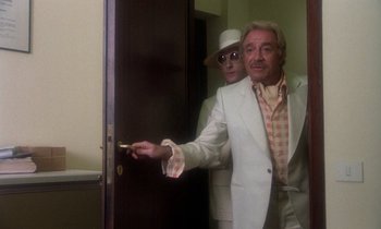 Movie still from “La Cage aux Folles” (1978), directed by Édouard Molinaro – A man in a white jacket and a man in a white suit; Medium shot, Low angle