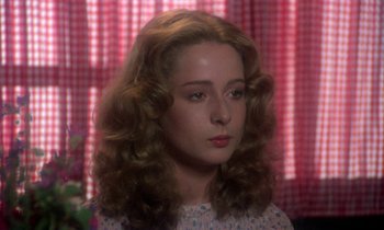 Movie still from “La Cage aux Folles” (1978), directed by Édouard Molinaro – A woman with long hair and a floral dress; Close Up shot, Over the shoulder angle