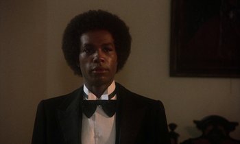 Movie still from “La Cage aux Folles” (1978), directed by Édouard Molinaro – A man in a suit and bow tie; Close Up shot, Low angle