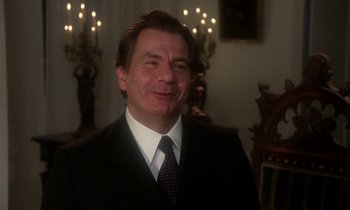Movie still from “La Cage aux Folles” (1978), directed by Édouard Molinaro – A person wearing a suit and tie; Close Up shot, Low angle