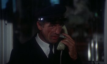 Movie still from “La Cage aux Folles” (1978), directed by Édouard Molinaro – A man wearing a hat talking on a phone; Close Up shot, High angle