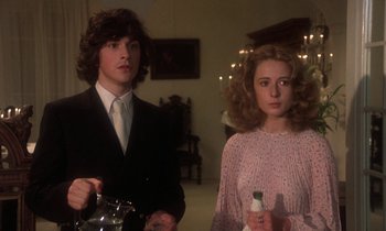 Movie still from “La Cage aux Folles” (1978), directed by Édouard Molinaro – A man and a woman standing next to each other in a room; Medium shot, Low angle