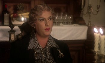Movie still from “La Cage aux Folles” (1978), directed by Édouard Molinaro – A woman with a black and white shirt and a black and white tie; Close Up shot, Over the shoulder angle