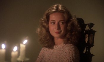 Movie still from “La Cage aux Folles” (1978), directed by Édouard Molinaro – A young woman with long blonde curly hair; Close Up shot, Over the shoulder angle