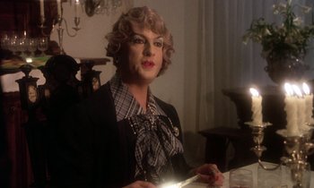 Movie still from “La Cage aux Folles” (1978), directed by Édouard Molinaro – A person with a light in a room; Close Up shot, Over the shoulder angle