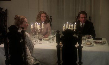 Movie still from “La Cage aux Folles” (1978), directed by Édouard Molinaro – A group of people sitting around a table with candles lit; Medium shot, High angle