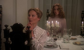 Movie still from “La Cage aux Folles” (1978), directed by Édouard Molinaro – Two women sitting at a dinner table in front of candles; Medium shot, Low angle